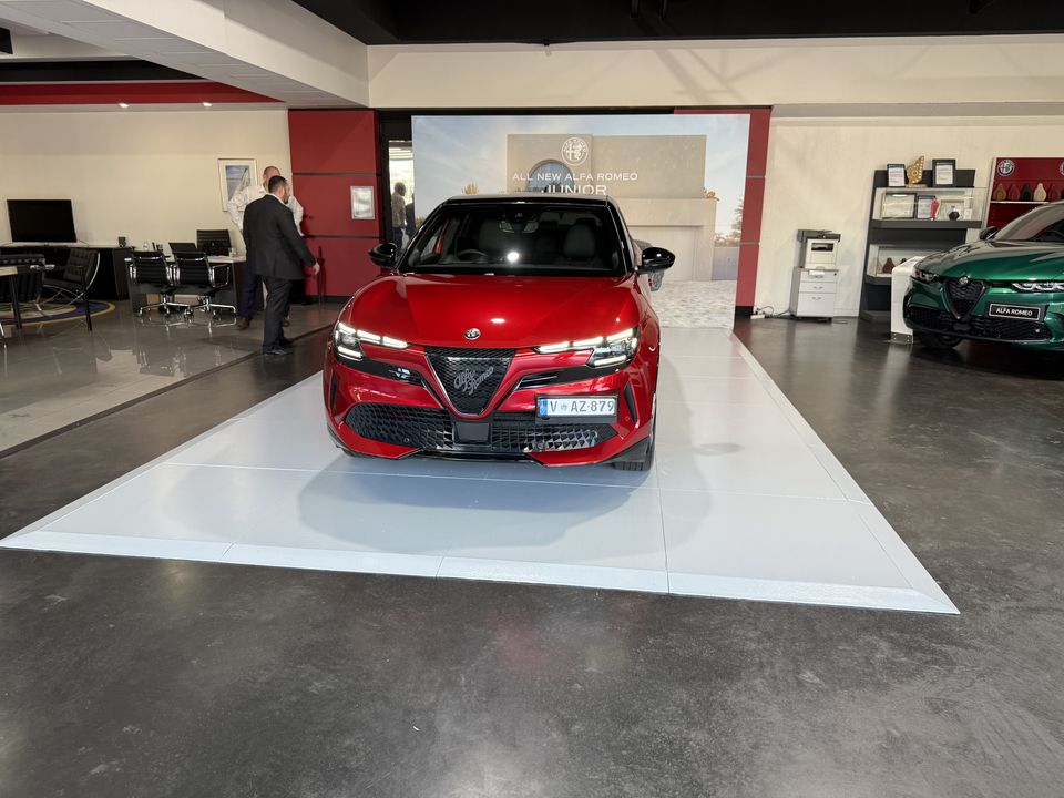 Red car on a white gloss display platform in a showroom