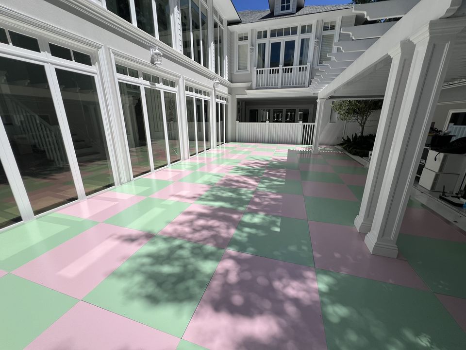 Pink and green chequered floor along a white colonnaded verandah