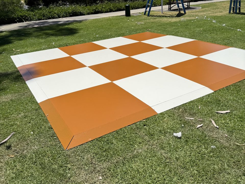 Orange and white chequered dance floor on grass in a park