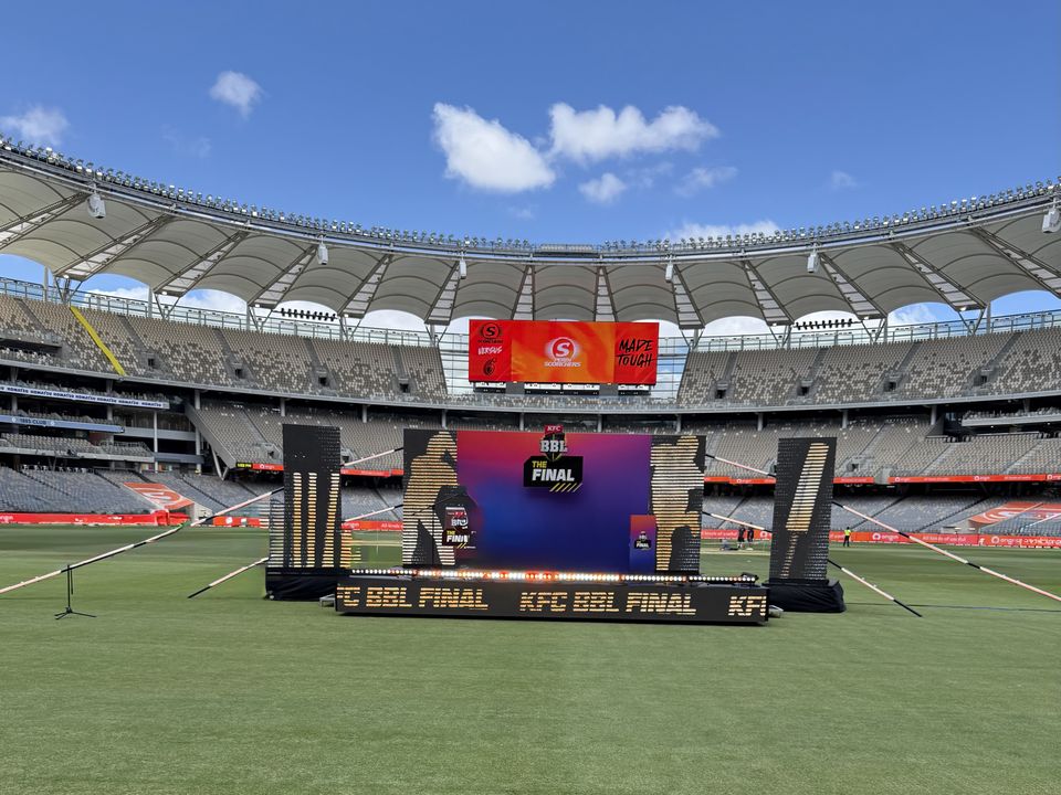 Rolling presentation stage with a branded backdrop on a stadium field
