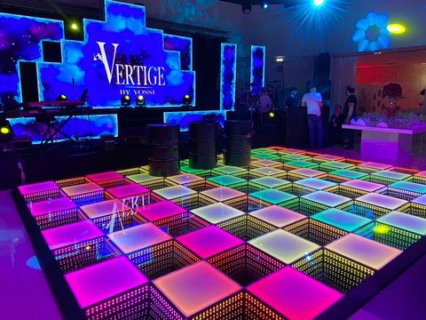 LED dance floor with coloured panels in front of a DJ stage