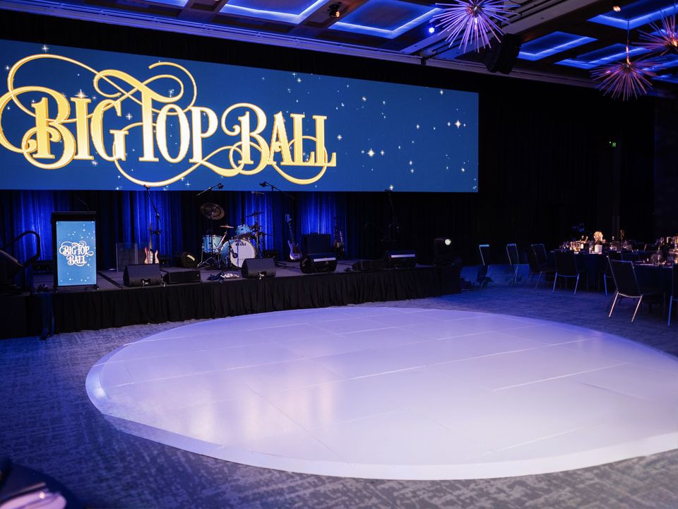 Round white dance floor in a ballroom in front of a band stage