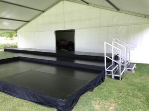 Stage on uneven ground under marquee